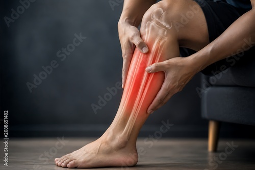 Person suffering from leg calf pain with medical visualization of human lower leg bones.