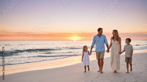 Family enjoying a summer sunset walk on the beach, creating lasting memories together