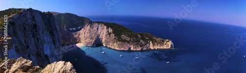 Paralia Navagio, Shipwreck Beach, panoramic photo, rocky cliff, shipwreck MV Panagiotis, excursion boats, blue and turquoise crystal clear sea, cloudless blue sky, Zakynthos, Ionian Islands, Greece