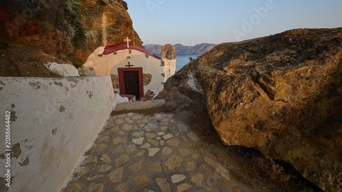 Legend, crab, shell fisherman, stone path to the chapel on the coast, surrounded by rocks, with calming sea view in the evening light, chapel, little church, Agia Kavouradena monastery, Xirokambos, Leros, Dodecanese, Greek Islands, Greece