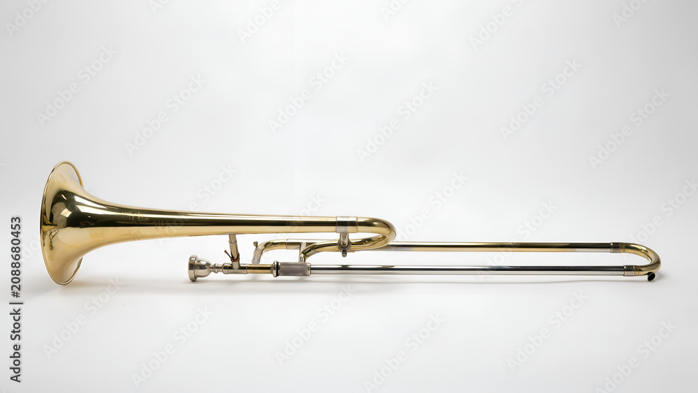 Obraz premium Golden brass trombone musical instrument isolated on a smooth surface with studio lighting and clear focus
