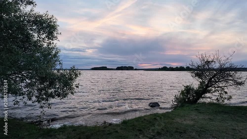 Slow Forward Camera Movement Along Windy Freshwater Lake Shore at Sunset