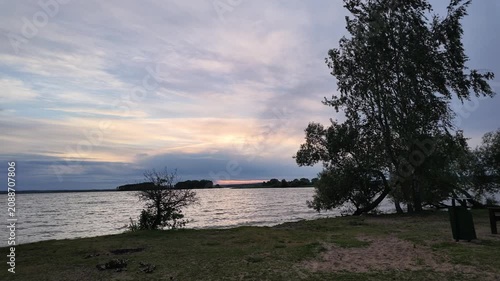 Slow Forward Camera Movement Along Windy Freshwater Lake Shore at Sunset