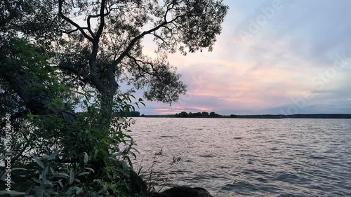 Slow Forward Camera Movement Along Windy Freshwater Lake Shore at Sunset
