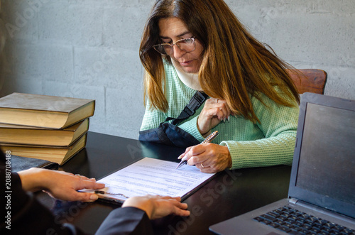 Konstfotografi Injured woman signing compensation contract during meeting with lawyer