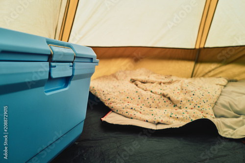 Blue cooler box and bedding inside a camping tent