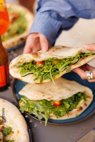 Flatbread sandwich with arugula and fresh vegetables
Vegetarian piadina with greens and tomato
Italian flatbread wrap served in restaurant