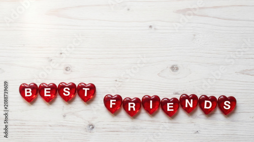Red heart shaped letter beads spelling Best Friends on a rustic wooden background, with copy spce, clebrating love, appreciation, companionship, kindness, loyalty, trust and Friendship Day