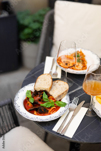 Restaurant table with gourmet dishes and wine
Elegant outdoor dining table in restaurant
Fine dining meal served on terrace with wine
