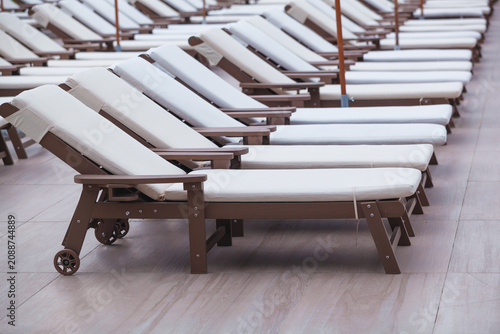 Fotografie sun loungers in the hotel near the pool without people