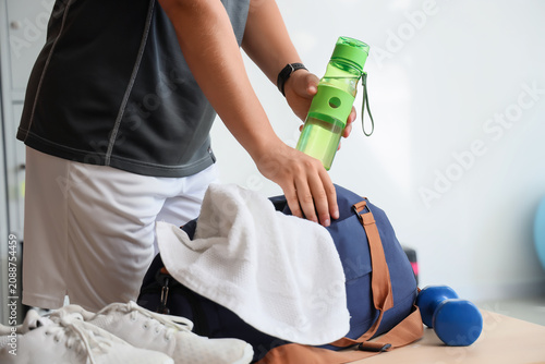 Man taking bottle of water ...