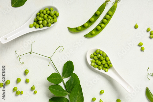 Spoons with fresh green pea...