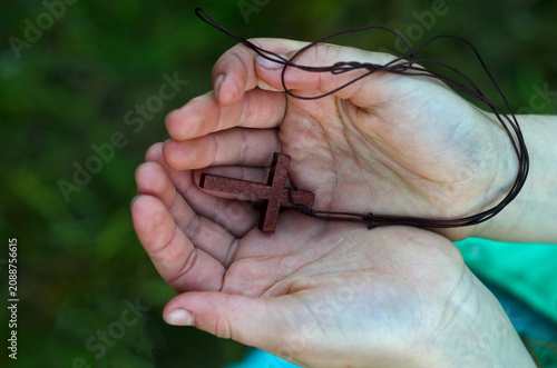 Christian wooden cross on girl hands, top view.Easter concept.