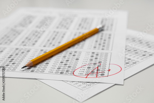 Pencil and answer sheets form of school test with results on white background...