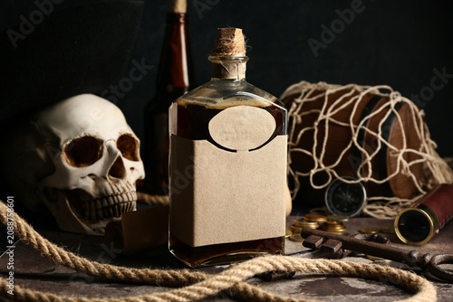 Photos Rum with key and rope on map, closeup. Pirate concept