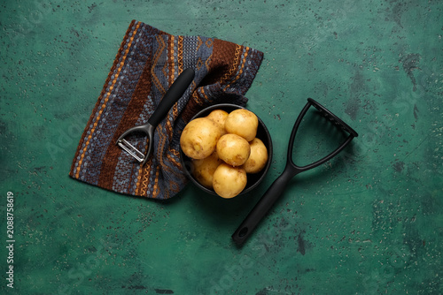Bowl with raw potatoes and ...