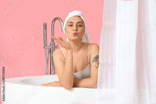 Young woman in bathtub with...