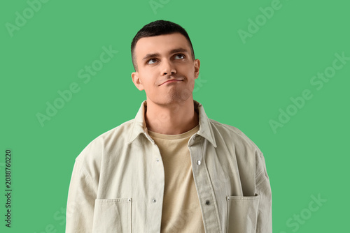 Thoughtful young man on gre...