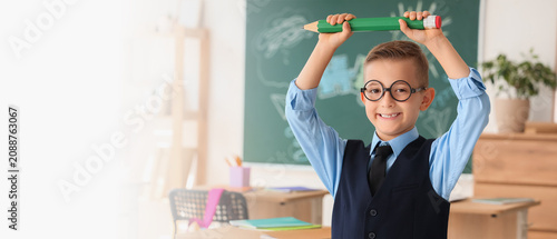 Smiling schoolboy holding o...