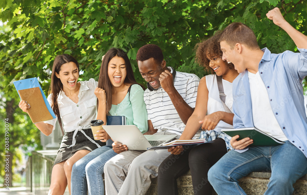 Obraz premium Exam Results. Group Of Joyful International Students Celebrating Success With Laptop Outdoors, Checking Their Test Scores Online