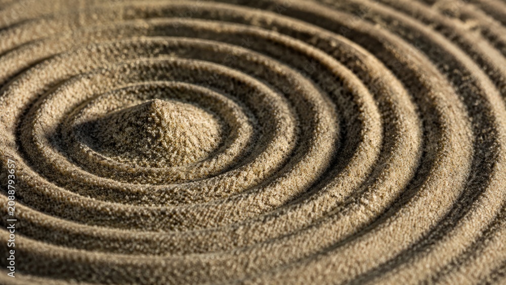 Naklejka premium Detailed view of a raked sand pattern in a Zen garden featuring concentric circles surrounding a central mound, creating a texture of tranquility and balance
