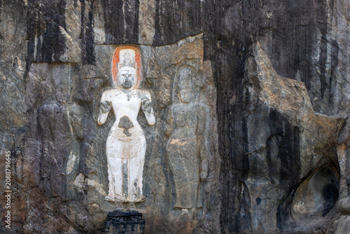 Beautiful Buddha statues carved directly onto a cliff in an ancient complex in Sri Lanka.