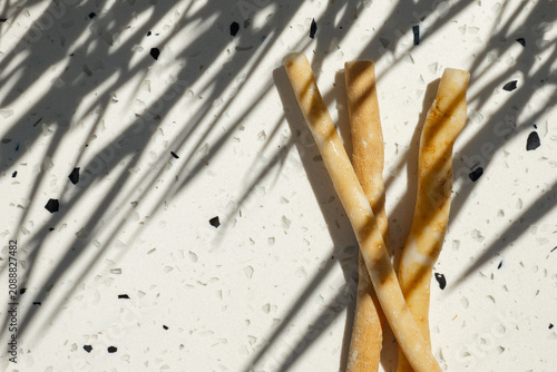  miswak chewing sticks on a light terrazzo surface in bright sunlight.Traditional natural toothbrush used for oral hygiene, dental care and sustainable zero waste lifestyle.