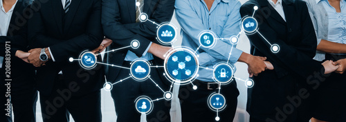 Фотография A diverse group of professionals in suits collaborating in a modern environment, symbolizing teamwork and digital connectivity, essential for today business landscape