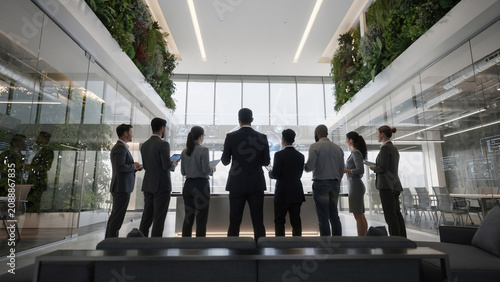 Business professionals in modern office interacting with holographic display, concept for team collaboration, innovation and data visualization