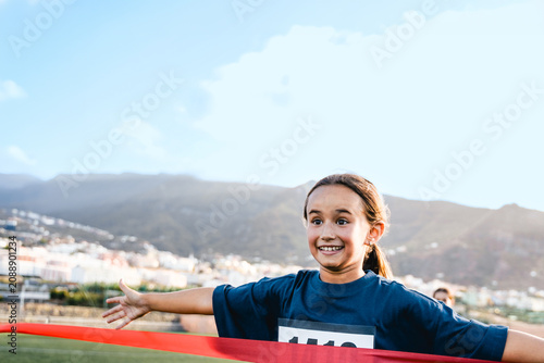 Sport child running to finish line during marathon race - Kid runner winning at sprint competition