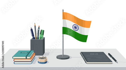 Desk setup featuring the national flag of India with stationery and notebooks.