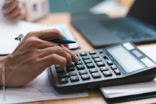 Obraz na plátne Accountant pressing calculator button for home evaluation report price