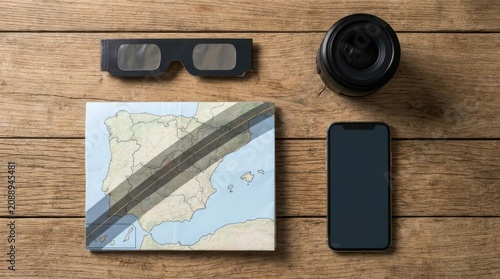 Flat lay of eclipse viewing gear on wooden table.