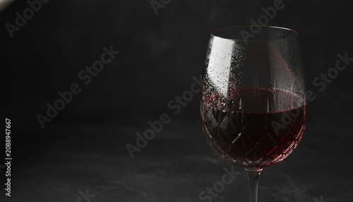 Chilled red wine in crystal glass on dark background