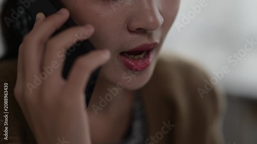 Close-up of a woman using a smartphone with focus on lips and hand