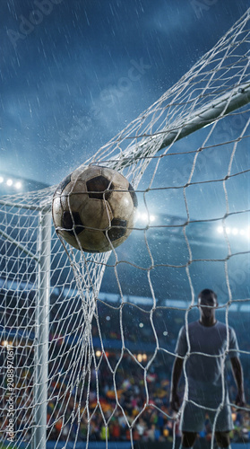 Soccer ball hitting the net during a rainy match