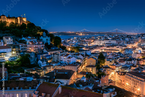 A panoramic view over the rooftops of Alfama and the Tagus River, from the Miradouro da Graca viewpoint in Lisbon, Portugal