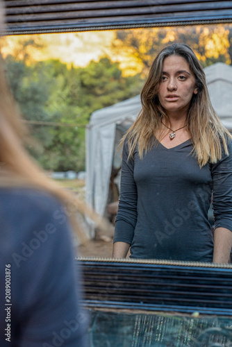 Woman seeing her reflection in an outdoor mirror