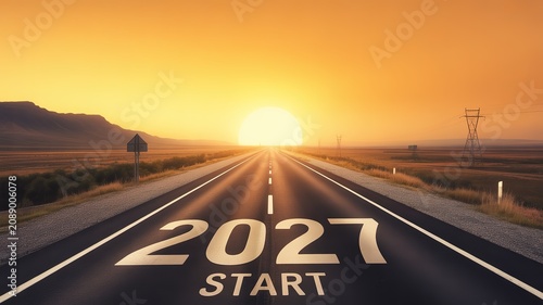 New Year 2027 Start Concept Open Highway Leading to Golden Sunset Over Vast Arid Landscape with Mountain Silhouettes and Utility Towers for Inspirational Designs