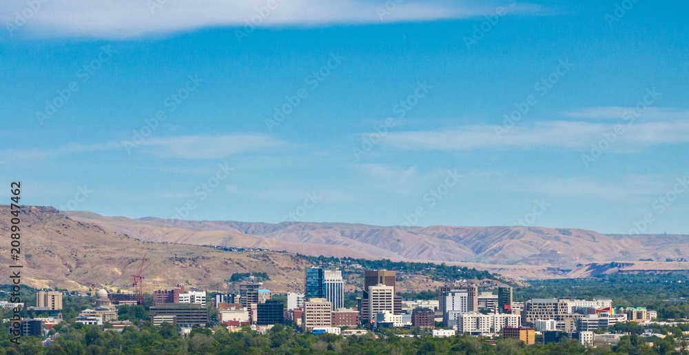 Obraz premium Panoramic view of a city with skyscrapers under a bright blue sky