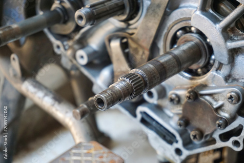 Cuadro en lienzo A detailed close-up shot of an open motorcycle engine crankcase during repair, showing the main transmission shaft, ball bearings, splines, and metallic casing assembly in a garage