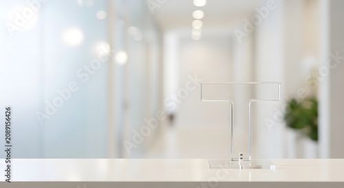 Clear acrylic sign holder on a white reception desk in a modern office or clinic hallway, with blurred background.
