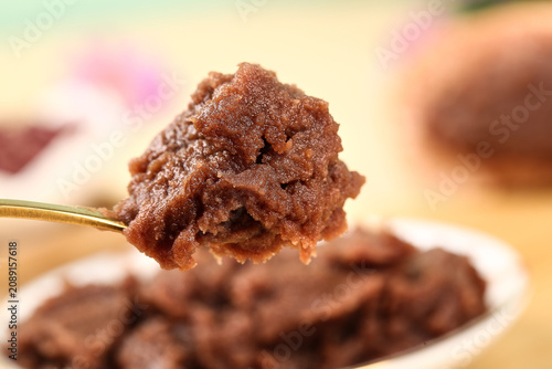 Red Bean Paste Mooncake Filling on Spoon with Traditional Pastries