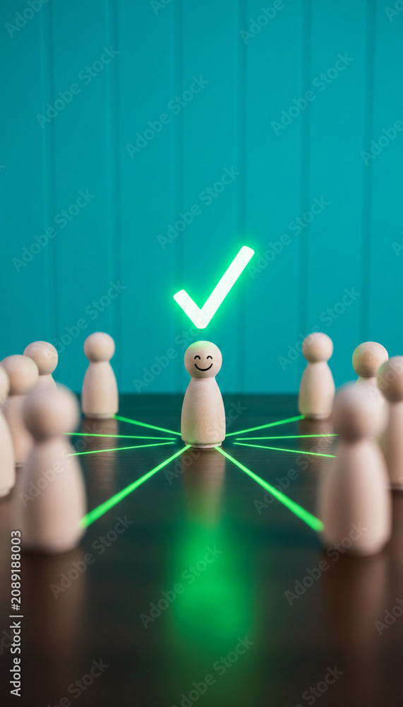 Obraz premium Wooden figures in a circle connected by light lines to one figure with a checkmark, symbolizing success, leadership, and selection, representative of teamwork or achievement