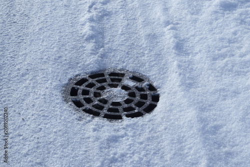 Water drainage gutter in snowy winter street