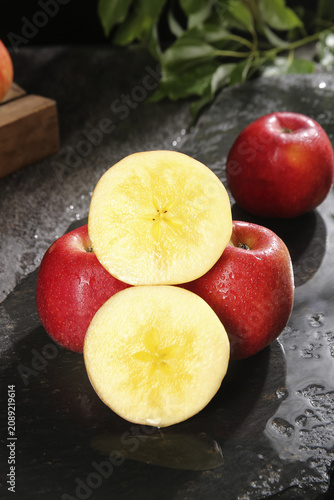 Canvastavla Fresh Red Apples Cut in Half Showing Star Pattern on Wet Stone Surface Still Lif