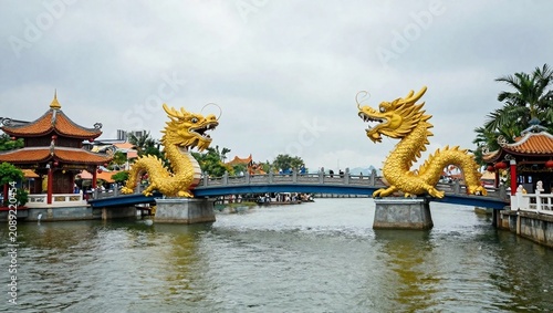 Traditional Chinese Footbridge Decorated with Two Golden Dragons Over Water