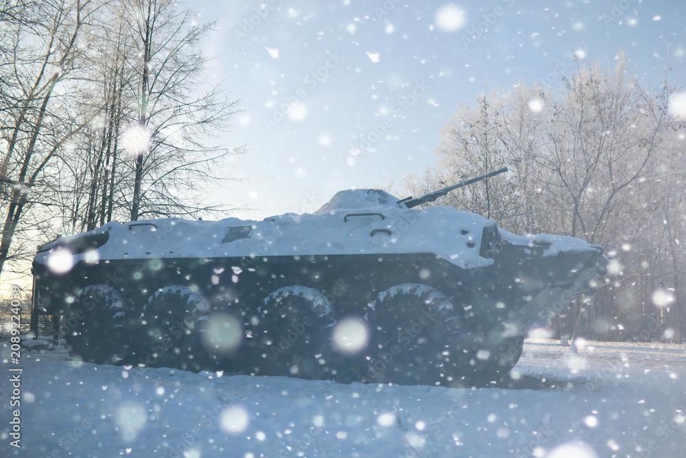 Naklejka premium Military tank in a row. Battle tank in the snow on the roadside of highway. War in Ukraine in winter.