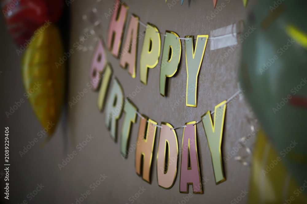 Fototapeta premium Colorful Happy Birthday Banner with Party Decorations on Wall