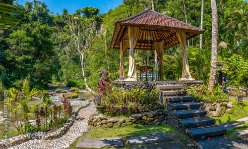 Ayung River and lush tropical hillside with traditional pavilion in Ubud, Bali, Indonesia